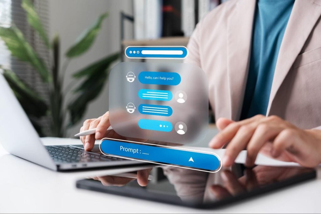 Person at laptop with tablet, digital chat and AI Voice Search icons illustrate contractor marketing to win leads for Hook Agency.