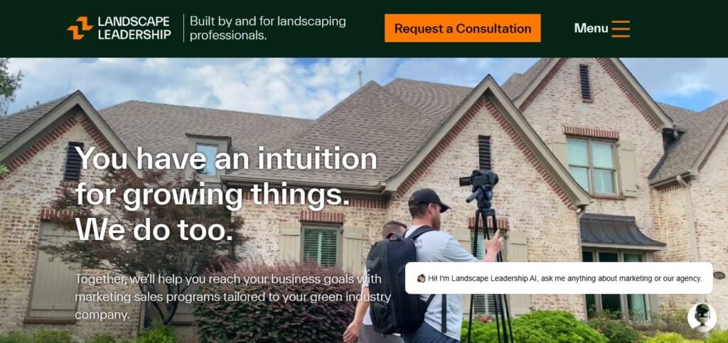 Two men prepare a video shoot outside a stone house with landscaped lawn; text spotlights marketing for landscape businesses.