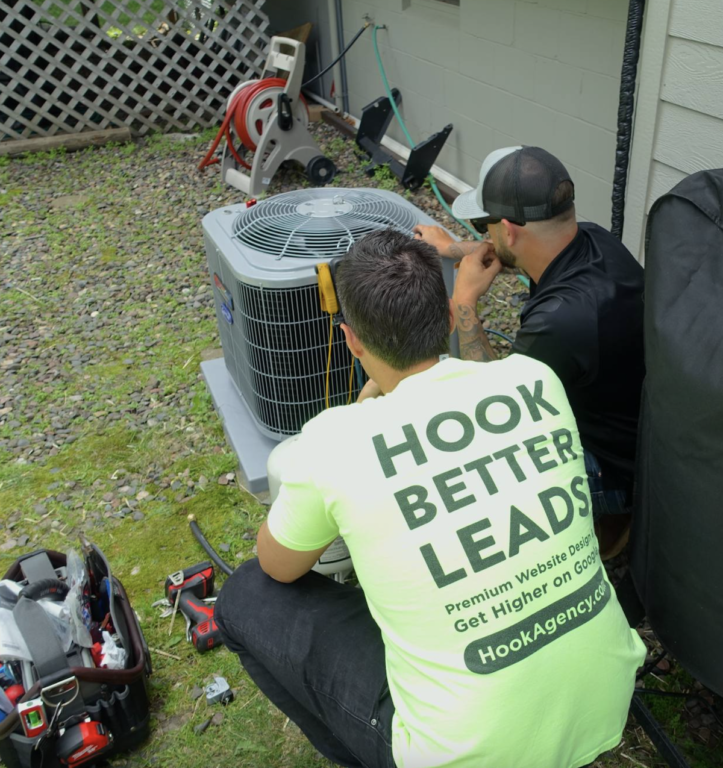 HVAC Marketing Tips Close-up of the owner of Hook Agency, a top-rated home services marketing agency with 150+ five-star Google reviews, crouched next to an HVAC unit, hands-on alongside an HVAC technician while installing the system. This image illustrates Hook Agency's commitment to being in the trenches with its clients, particularly HVAC companies, to fully understand their business needs. With personalized digital marketing solutions, website design, and lead generation strategies, Hook Agency helps HVAC, plumbing, and other home service businesses thrive online, driving growth through tailored SEO and paid advertising campaigns.