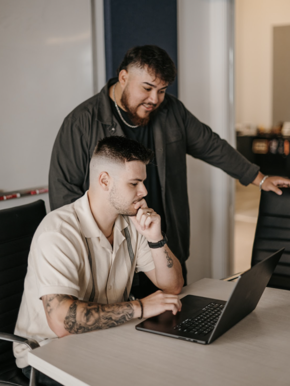 Two PPC specialists discussing a roofing ad account strategy, representing the expert approach a roofing Google Ads management team takes to optimize PPC campaigns for maximum lead generation and ROI.