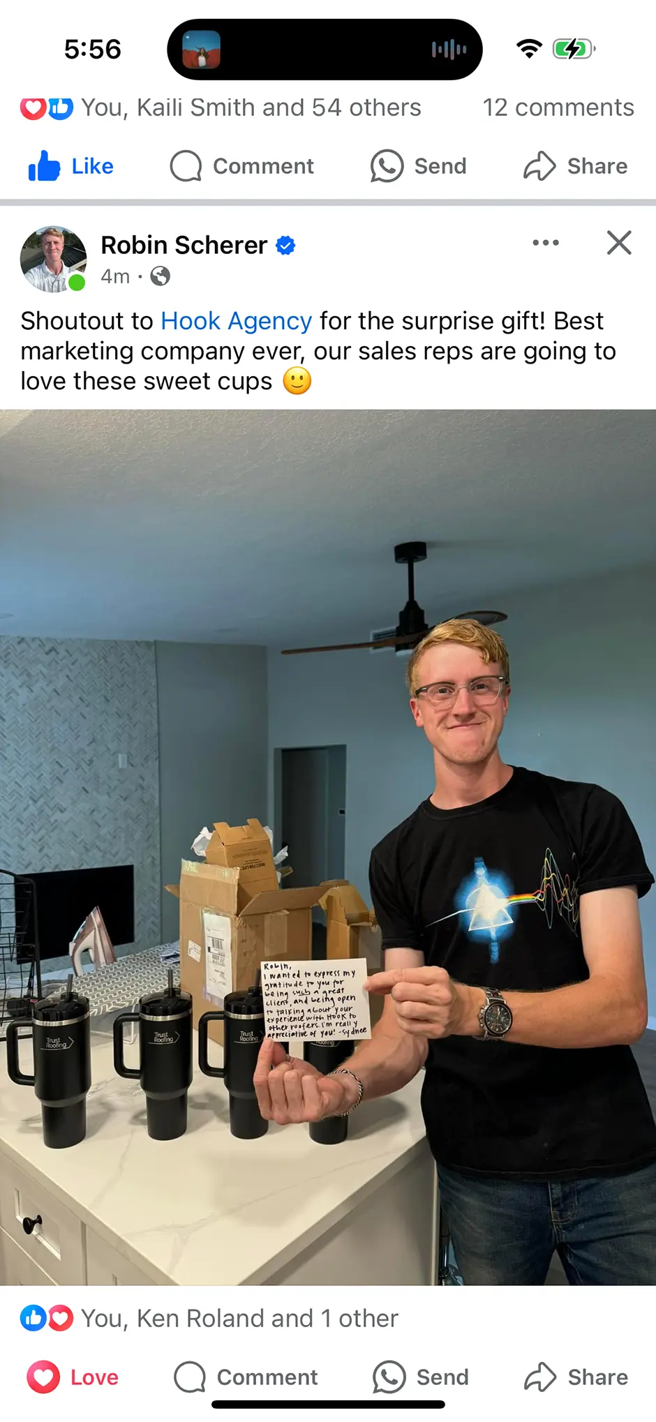 A person stands smiling in a kitchen, holding a black cup with a message card. Several similar cups line the counter. The social media post expresses gratitude to Hook Agency for the thoughtful gift and invites others to check out glowing Hook Agency reviews.